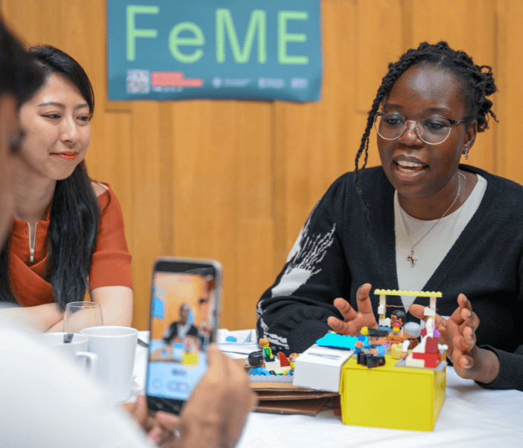 College student holding her robotic toy at robotics classroom at school